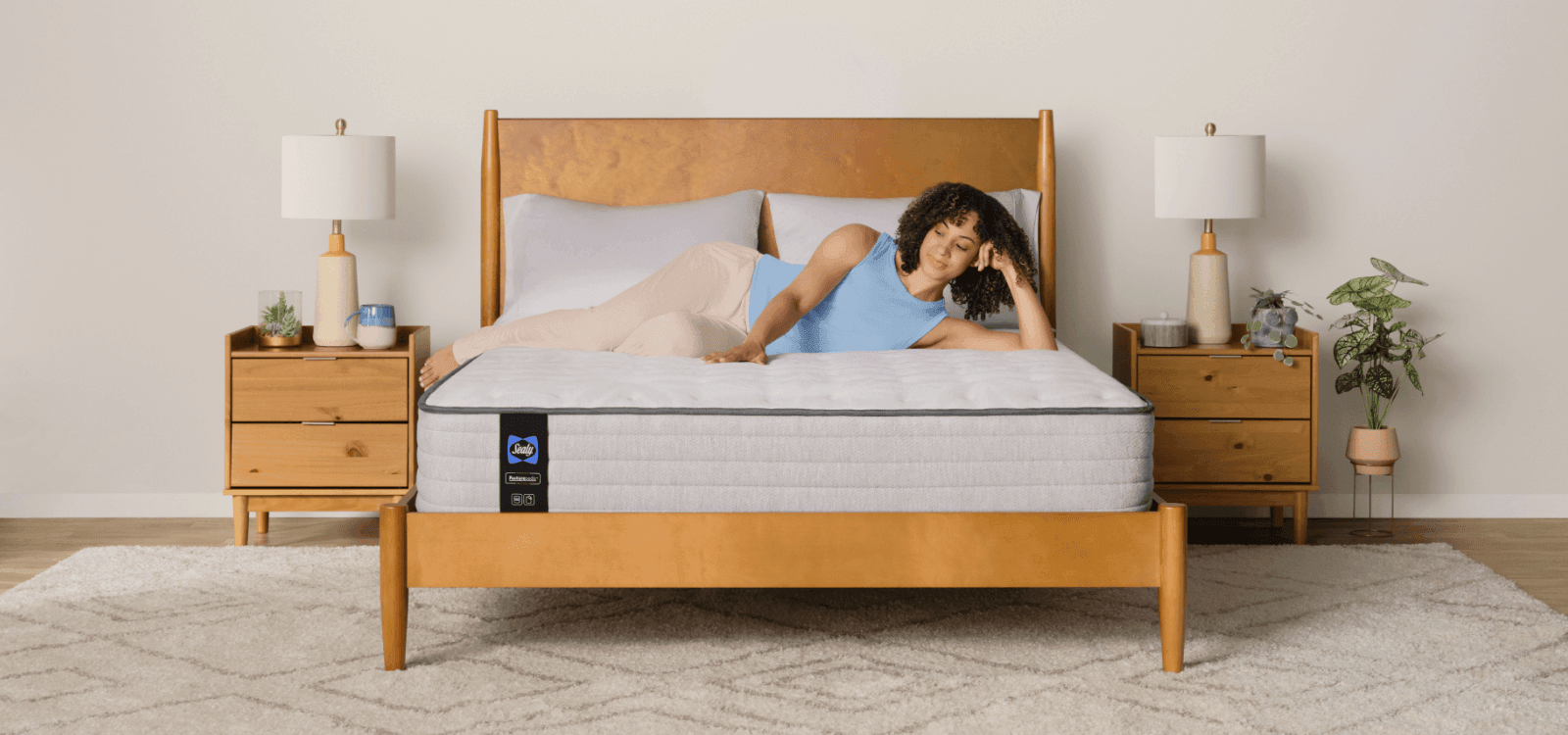 A lifestyle image of a model laying on a Posturepedic Spring mattress