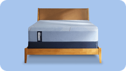 Posturepedic Hybrid mattress on a foundation with a blue background