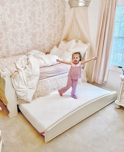 little girl jumping on bed
